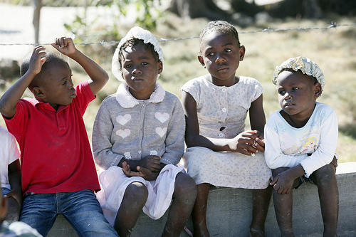 Young children sit outside together at a displaced persons camp situated at the Sports Center of Carrefour, Port-au-Prince, on Jan. 6, 2012. / Credit:Stuart Ramson/Insider Images for UN Foundation